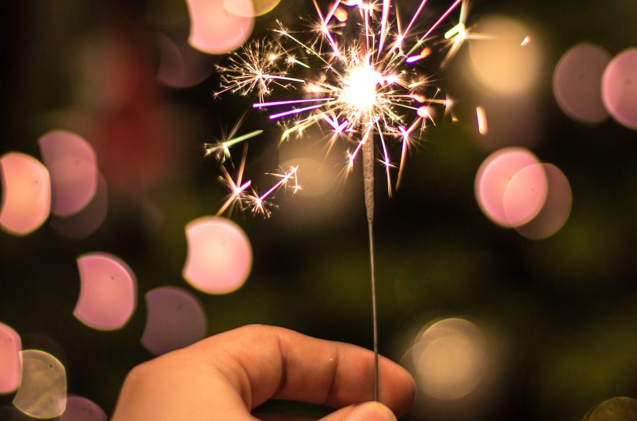 bokeh photography of person holding fireworks